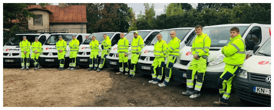 DrilleR zāģēšanas un urbšanas meistaru komanda pilnā sastāvā stāv pie busiem