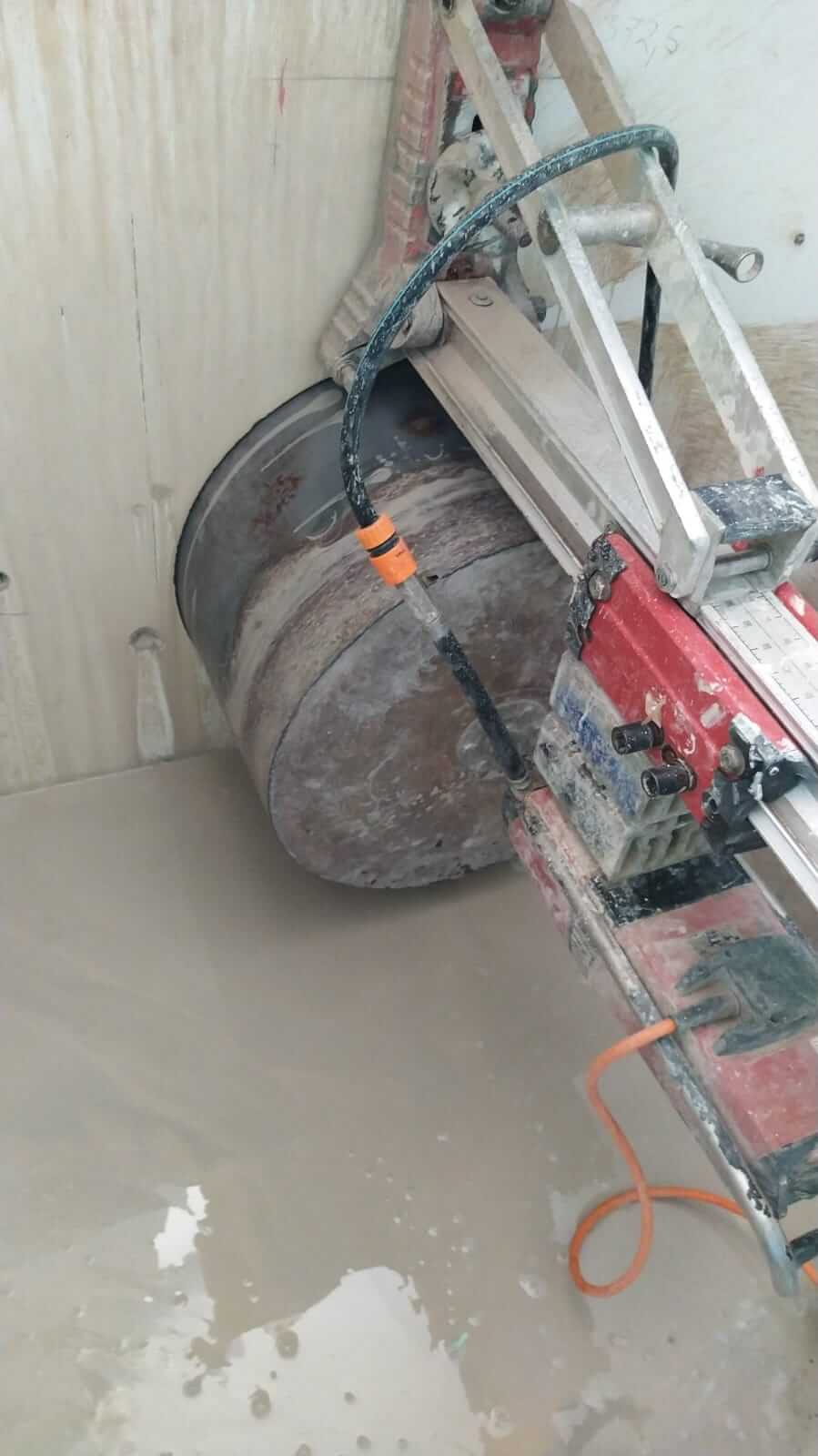 cauruma urbšana ēkas sienā no ārpuses ar liela diamtera kroņurbis 