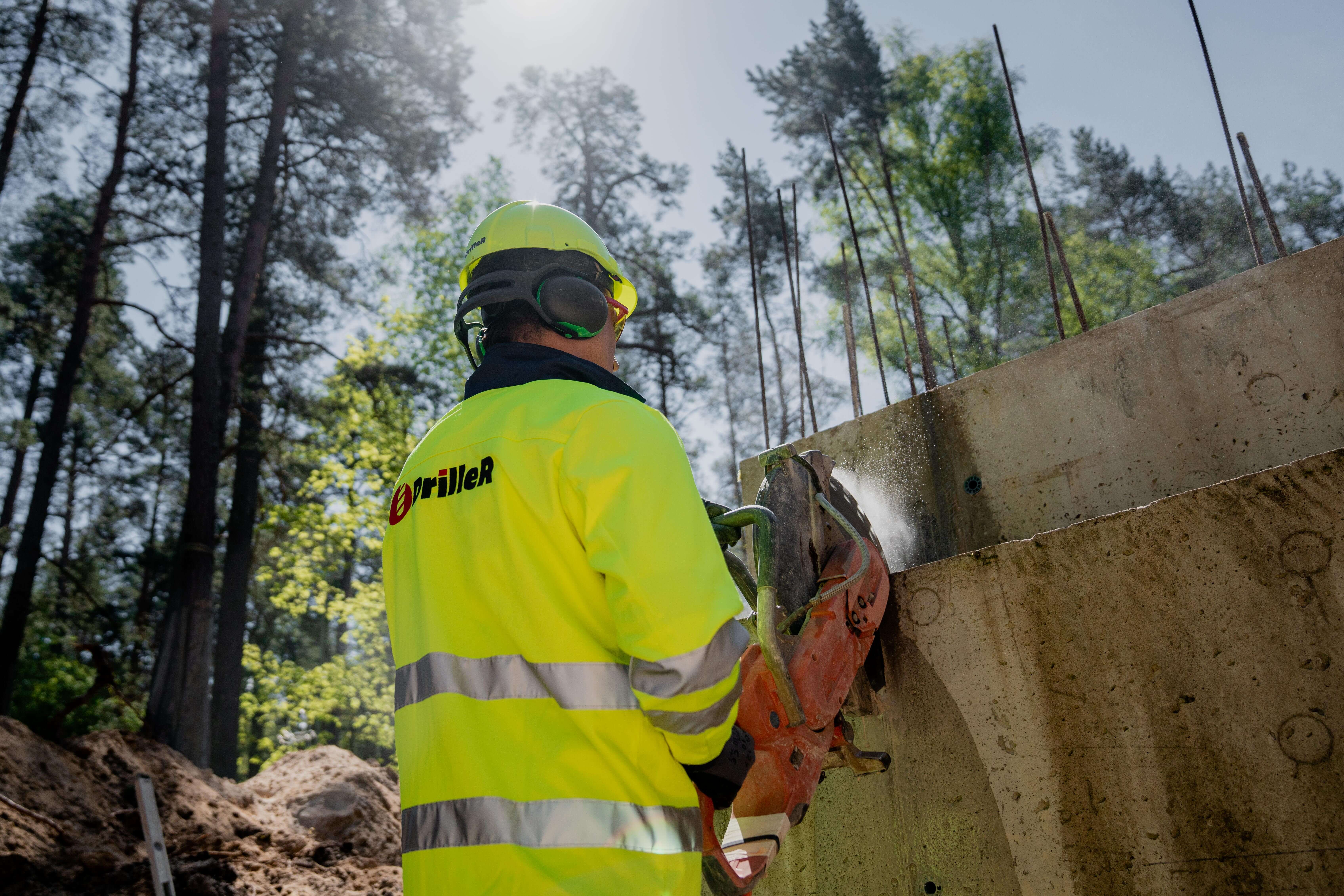 DrilleR meistars zāģē betona sienu būvlaukumā