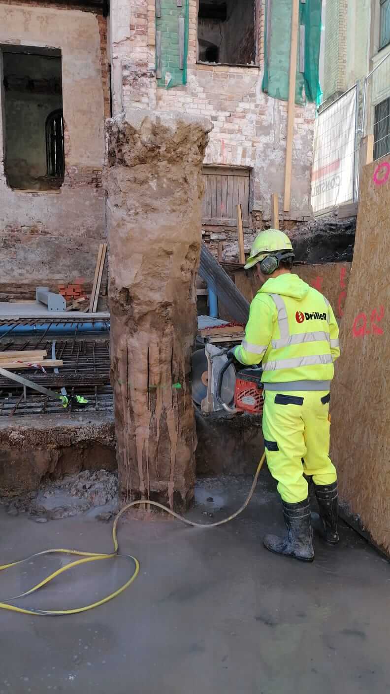Driller meistars zāģē ķieģeļu kolonnu